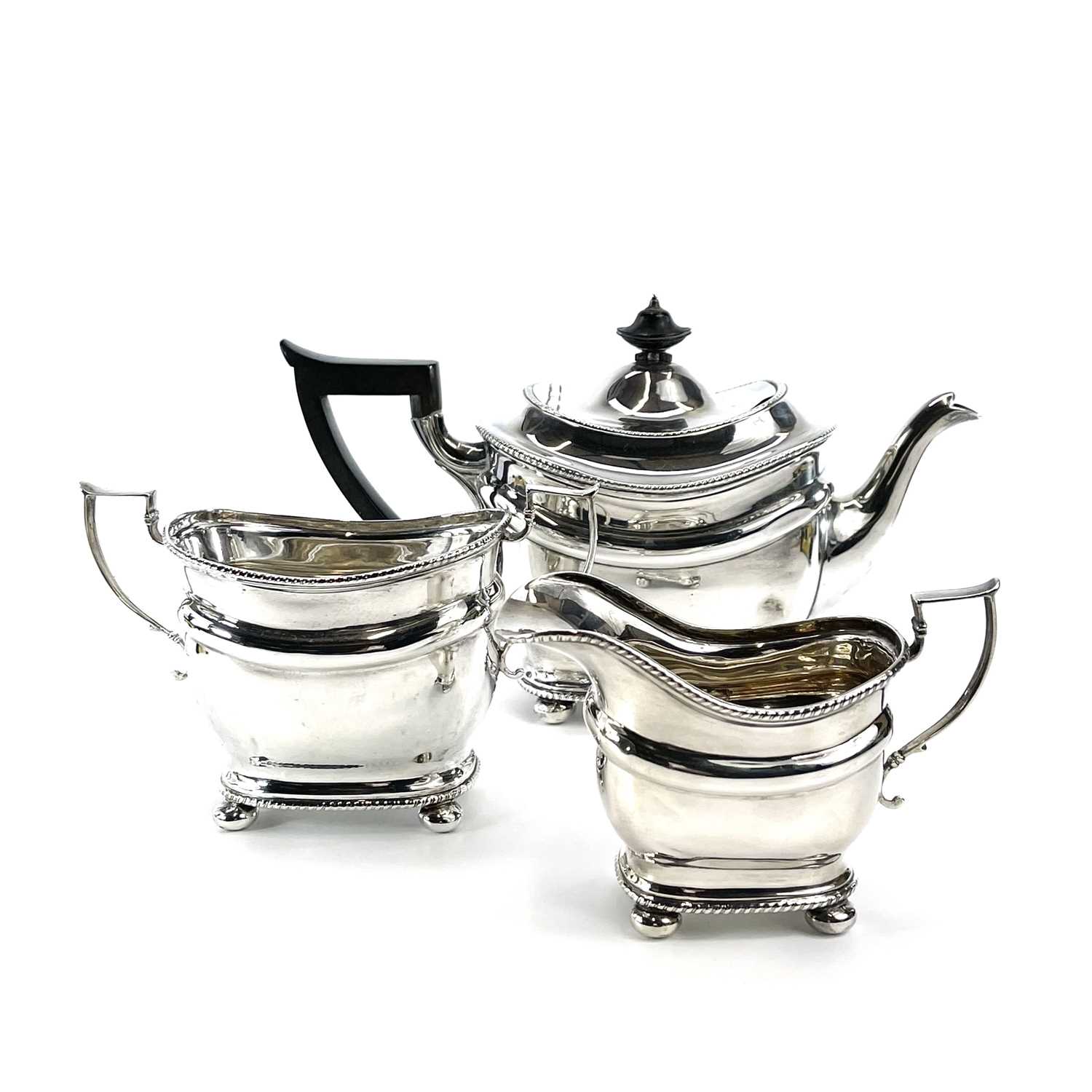 A George V silver three piece tea set by Thomas Bradbury & Sons Ltd, of oblong form with gadrooned