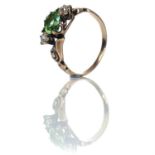 A gold diamond and green tourmaline three stone ring, the oval cut tourmaline measuring 0.50ct and