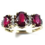 A 14ct ruby and diamond ring, the central oval ruby measures 0.75ct approximately and flanked by two