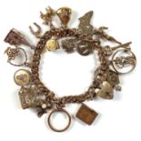 A 9ct gold charm bracelet with 19 various 9ct charms, weight 57.9g.The links on the bracelet are