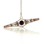 A 9ct gold garnet and seed pearl set bar brooch, base metal pin, width 57mm, weight 3.75g.