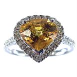 An 18ct white gold yellow sapphire and diamond cluster ring, the sapphire measuring 2.87ct, size