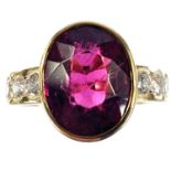 An 18ct gold pink tourmaline and diamond set seven stone dress ring, the oval tourmaline in a collet