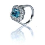 An exquisite fancy vivid blue diamond set cluster ring, the certified blue emerald cut diamond