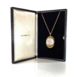 A 1970's 9ct hallmarked gold oval pendant locket on fancy belcher necklace, the locket with scroll