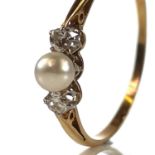 An 18ct diamond and pearl set three stone ring, the pearl measuring 4mm diameter, flanked by two