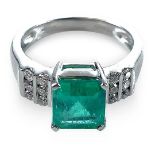 An attractive platinum diamond and emerald cluster ring, the emerald cut stone measuring 2ct