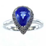 An 18ct white gold cornflower blue sapphire diamond cluster ring, the pear shaped sapphire measuring