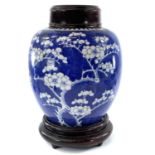 A Chinese blue and white porcelain prunus pattern ginger jar, 19th century, with carved wood cover