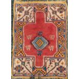 A Turkish Ushak rug, the madder field with a central polychrome medallion and animals, 112 x 80cm.
