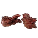 A pair of Chinese carved wood candle holders modelled as stylised dragons, 19th century, each with
