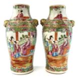 A pair of Chinese Canton porcelain vases, 19th century, each with a panel enclosing figures in an