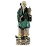 A Chinese sancai-glazed standing figure, 17th/18th century, wearing a green robe and holding a