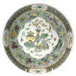 A Chinese famille verte porcelain dish, decorated with precious objects to the centre, painted