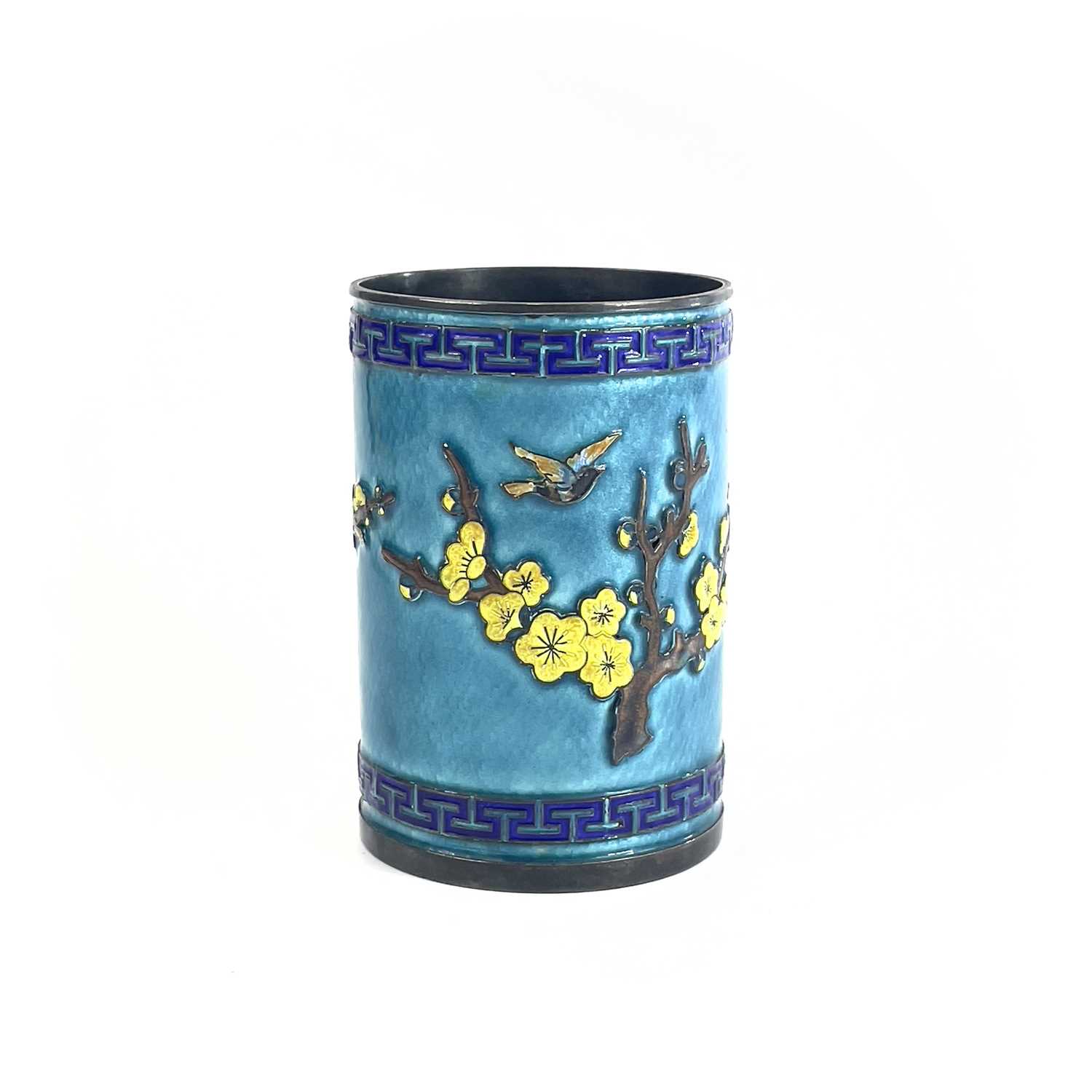 A Chinese silver and enamel brush pot, decorated in relief with a flowering tree and birds, height