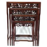 A Chinese hardwood quartetto nest of tables, early 20th century, each carved with fruit and