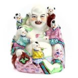 A Chinese famille rose porcelain figure of Buddha with five boys, 20th century, impressed mark on