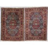 A pair of Tabriz rugs, North West Persia, the indigo field with a central lobed madder medallion,