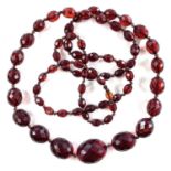 A cherry 'amber' bakelite graduated bead necklace, length 104cm, 64 grams.