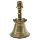 An Islamic brass candlestick, 19th century, with cylindrical base, decorated with panels of