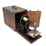 A Willcox and Gibbs 'Silent' sewing machine, with a mahogany base and contained in a metal bound