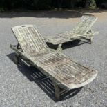 A pair of teak sunloungers with adjustable backs.Each lacks one of it's folding arms