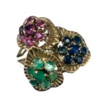 An 18ct gold emerald, ruby and sapphire set triple daisy head ring.