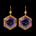 A pair of Victorian yellow metal mounted hexagonal cut amethyst earrings.