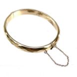 A continental yellow metal hollow hinged bangle.