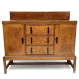 An Arts and crafts oak sideboard,with three central drawers flanked by a pair of doors on square