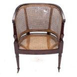 A Regency mahogany Bergere armchair, with rattan back and seat, on turned tapering front legs,