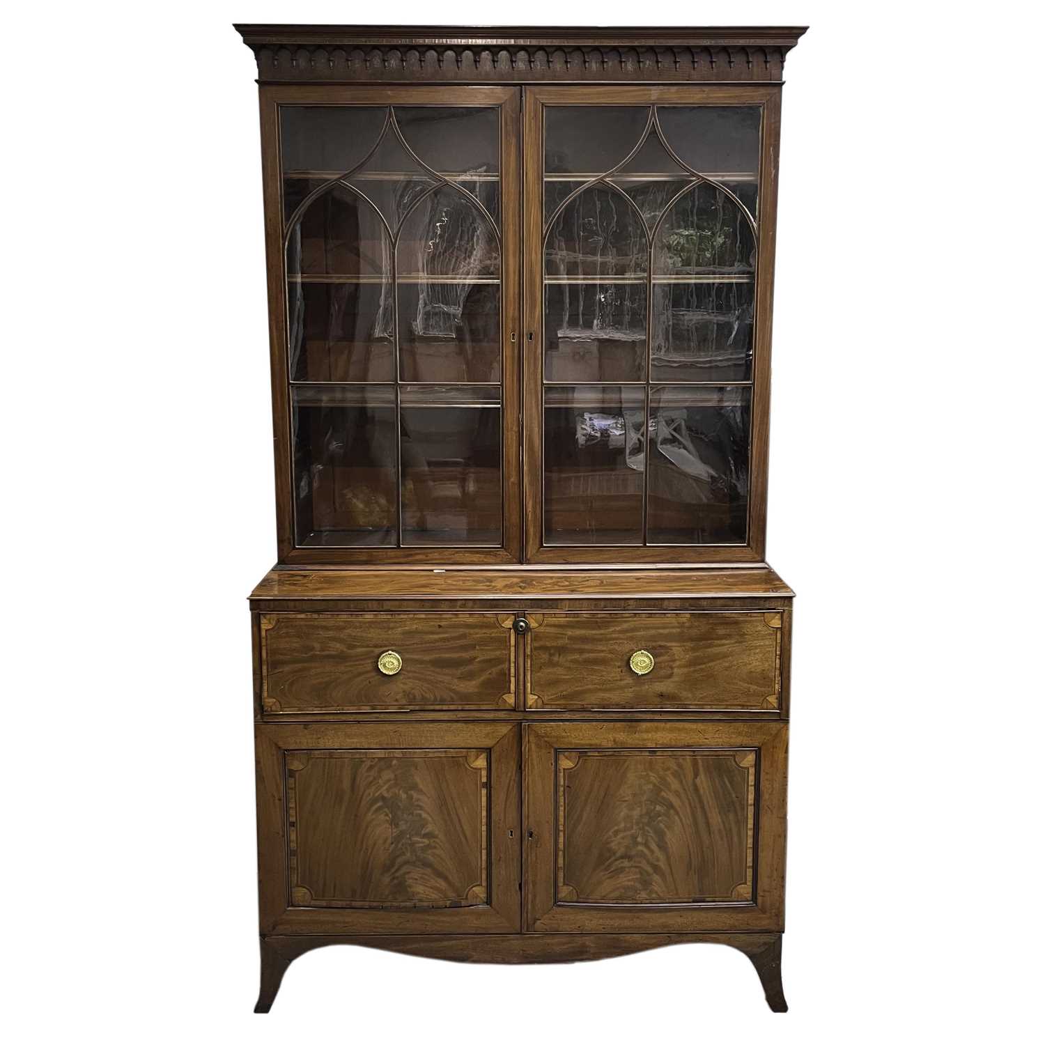 A George III mahogany and satinwood banded secretaire bookcase, with arcaded frieze, above two