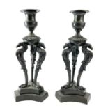 A pair of Bronze candlesticks, mid 19th century, each with a removable sconce and raised upon triple