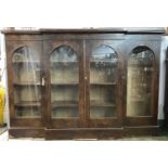 A Victorian mahogany breakfront low bookcase, the four glazed doors with arched tops, on a plinth