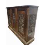 An Arts and Crafts oak cupboard, dated 1931, with three doors carved with hops, flowers and a