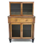 A Regency rosewood and kingwood banded secretaire cabinet, the upper part with two glazed doors with