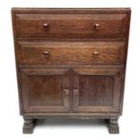 An Arts and Crafts oak bedroom cabinet, circa 1930, in the Cotswolds taste, fitted with two long