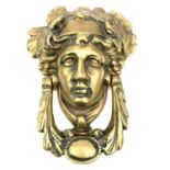 A brass door knocker modelled as a Classical female mask, height 17cm.