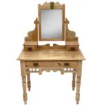 An Edwardian pine dressing table, fitted with a swing mirror and three drawers on turned legs,