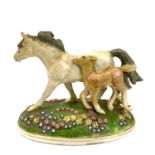 Kate Westrup, a pottery mare and foal group, the oval base with applied scattered flowerheads,