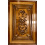 A late Victorian walnut panel, centrally carved with a bowl of fruit atop a leafy torchere