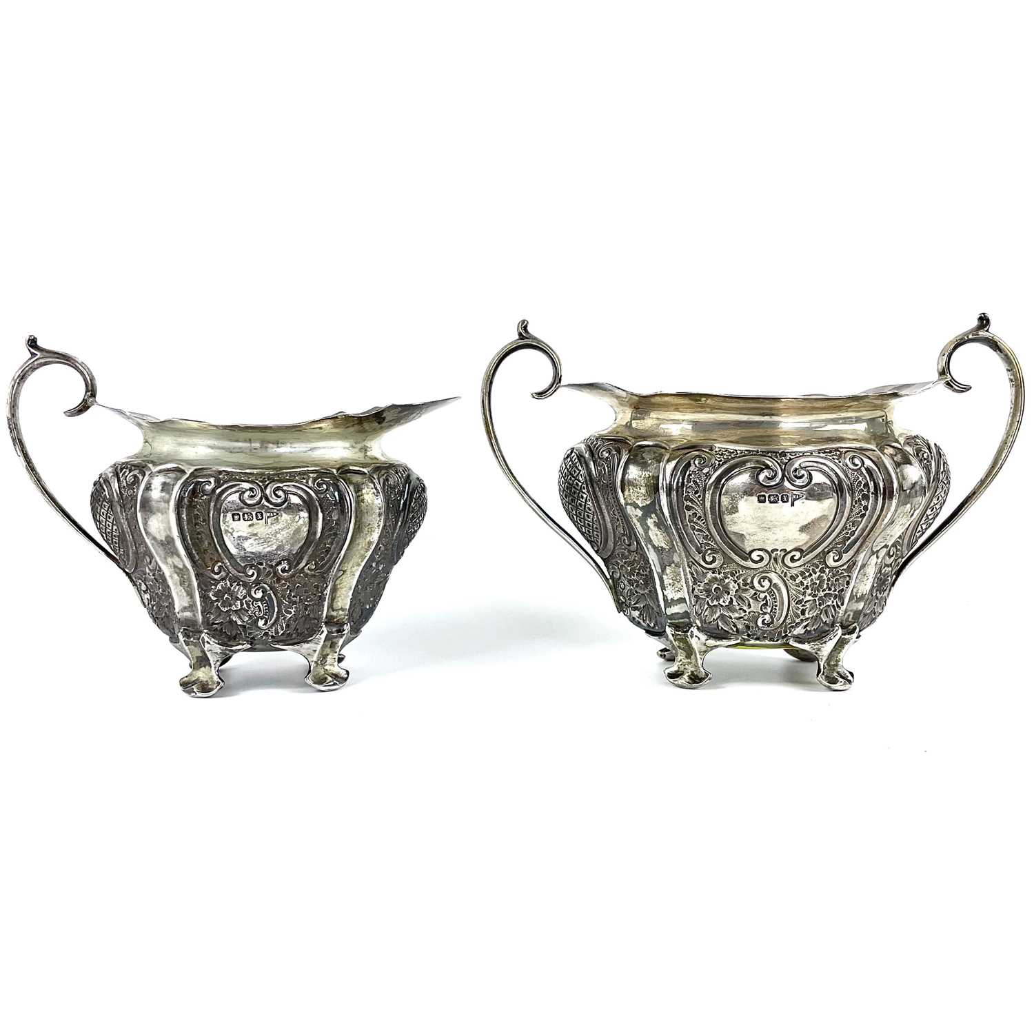 A George V silver cream jug and sugar bowl by Walker & Hall.