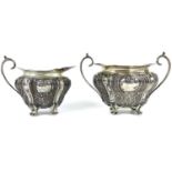 A George V silver cream jug and sugar bowl by Walker & Hall.