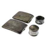 Two silver cigarette cases and two napkin rings.
