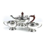 A silver three piece tea set by Mappin & Webb, of circular pedestal form,