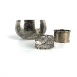 A silver hammered bowl and two silver napkin rings.