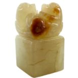 A Chinese carved pale jade and russet seal, Qing Dynasty.