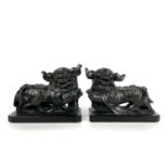 A pair of Chinese black hardstone models of dogs of fo, early-mid 20th century.