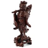 A Chinese carved wood figure of a man carrying a staff and holding a peach, late 19th century.