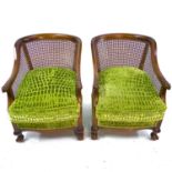 A pair of Art Deco Bergere armchairs with curved backs and carved feather, talon and ball armrests.